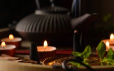 Composição de cone de incenso ardente, bule de chá e velas — Fotografia de Stock