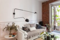 Aconchegante sala interior com sofá e parede de tijolo — Fotografia de Stock