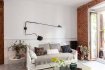 Aconchegante sala interior com sofá e parede de tijolo — Fotografia de Stock