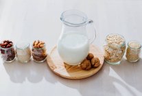 Ingredientes para preparar leche vegana en la mesa - foto de stock