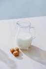 Frasco de leite e nozes na mesa — Fotografia de Stock