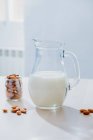Glas Milch und Mandeln auf dem Tisch — Stockfoto