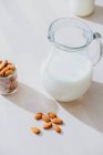 Glas Milch und Mandeln auf dem Tisch — Stockfoto