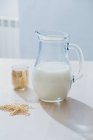 Jar of milk and oatmeal on table — Stock Photo