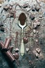 From above top view spoon with chocolate spilled over rustic metal surface background — Stock Photo