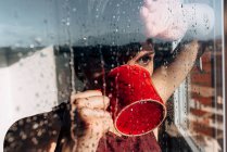 Задумчивая женщина пьет кофе у окна — стоковое фото