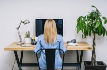 Blonde Caucasian woman works from her home office — Stock Photo