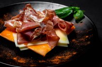 Pain grillé fait maison avec jambon et différents types de fromages sur fond sombre — Photo de stock