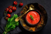Здоровий домашній томатний суп з хлібом, монетним двором та оливковою олією на темному тлі зверху. концепція веганської їжі — стокове фото