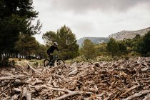 Велосипедист катается на велосипеде по скалистой дороге в лесу — стоковое фото