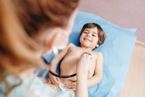 Arzt mit Stethoskop untersucht Kind in Klinik — Stockfoto