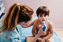 Niño enfermo recibiendo tratamiento por inhalación en la clínica - foto de stock