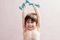 Cheerful little boy with dumbbells — Stock Photo