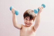 Cheerful little boy with dumbbells — Stock Photo