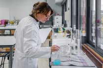 Femme adulte travaillant dans un laboratoire de chimie — Photo de stock