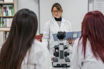 Зріла жінка навчає студентів в лабораторії — стокове фото