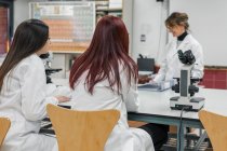 Mature woman teaching students in lab — Stock Photo