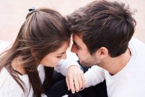 Desde arriba vista lateral de cariñosa tierna joven pareja abrazándose y besándose mientras tienen momentos románticos juntos - foto de stock