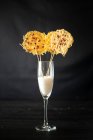 Bicchiere con riso per la decorazione di patatine croccanti grattugiate su bastoncini disposti su fondo nero — Foto stock