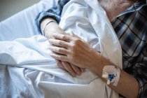 Von oben ältere Patientin mit intravenösem Katheter im Arm unter Decke liegend und schlafend — Stockfoto
