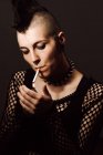 Adult female with mohawk and piercing smoking cigarette — Stock Photo