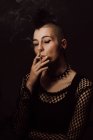 Erwachsenes Weibchen mit Mohawk und Piercing beim Zigarettenrauchen — Stockfoto