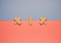 Knusprige Kekse auf grauen und korallenen Papierbögen — Stockfoto