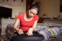 Jeune Asiatique ethnique femelle avec anneau sur doigt rose tourner vis tout en installant poignée sur chaise à la maison — Photo de stock