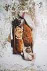 Зверху сільська композиція з ароматним хлібом на дошці з лляним рушником і ножем на шпагаті — стокове фото