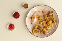 Hausgemachte maurische Spieße mit Fleischreis mit Gewürzen. Typisch orientalisches Essen von oben auf beigem Hintergrund. Flach lag er. Ansicht von oben — Stockfoto