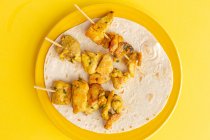 Homemade Moorish skewers with rice of meat with spices. Typical oriental food from above on yellow background. Flat lay. Top view — Stock Photo