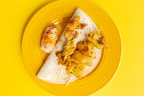 Hausgemachte maurische Spieße mit Fleischreis mit Gewürzen. Typische orientalische Speisen von oben auf gelbem Hintergrund. Flach lag er. Ansicht von oben — Stockfoto