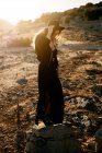 Стильна жінка стоїть на скелі в сільській місцевості — стокове фото