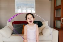 Cute happy little brunette girl with ribbon with closed eyes during rhythmic gymnastic training at home — Stock Photo