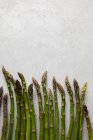 Flat lay of fresh asparagus on white marble table — Stock Photo