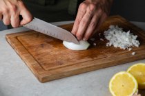 Preparation chopping onion on wooden cutting board — Stock Photo
