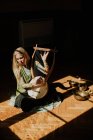 Woman playing lyre in dark room — Stock Photo