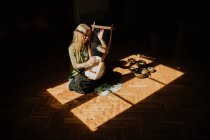 Женщина играет на лире в темной комнате — стоковое фото