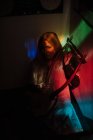 Donna che gioca lira sotto la luce colorata — Foto stock
