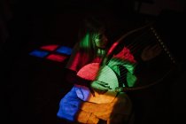 Mujer jugando lira bajo luz colorida - foto de stock
