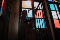Woman with lyre standing near stained glass windows — Stock Photo