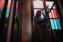 Femme avec lyre debout près des vitraux — Photo de stock