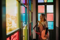 Donna con lira in piedi vicino a vetrate — Foto stock