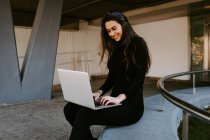 Жіночий фрілансер використовує ноутбук у дворі — стокове фото