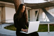 Женщина-фрилансер с ноутбуком во дворе — стоковое фото