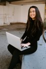 Женщина-фрилансер с ноутбуком во дворе — стоковое фото