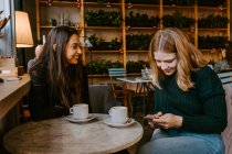 Female friends resting in cozy cafe — Stock Photo