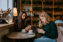 Amis féminins se reposant dans un café confortable — Photo de stock