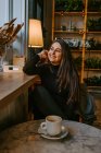 Mulher encantada bebendo café no café — Fotografia de Stock