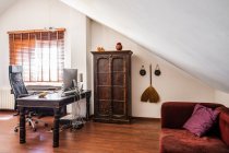 Робоче місце з вінтажними дерев'яними меблями і східним декором в сучасній квартирі — стокове фото